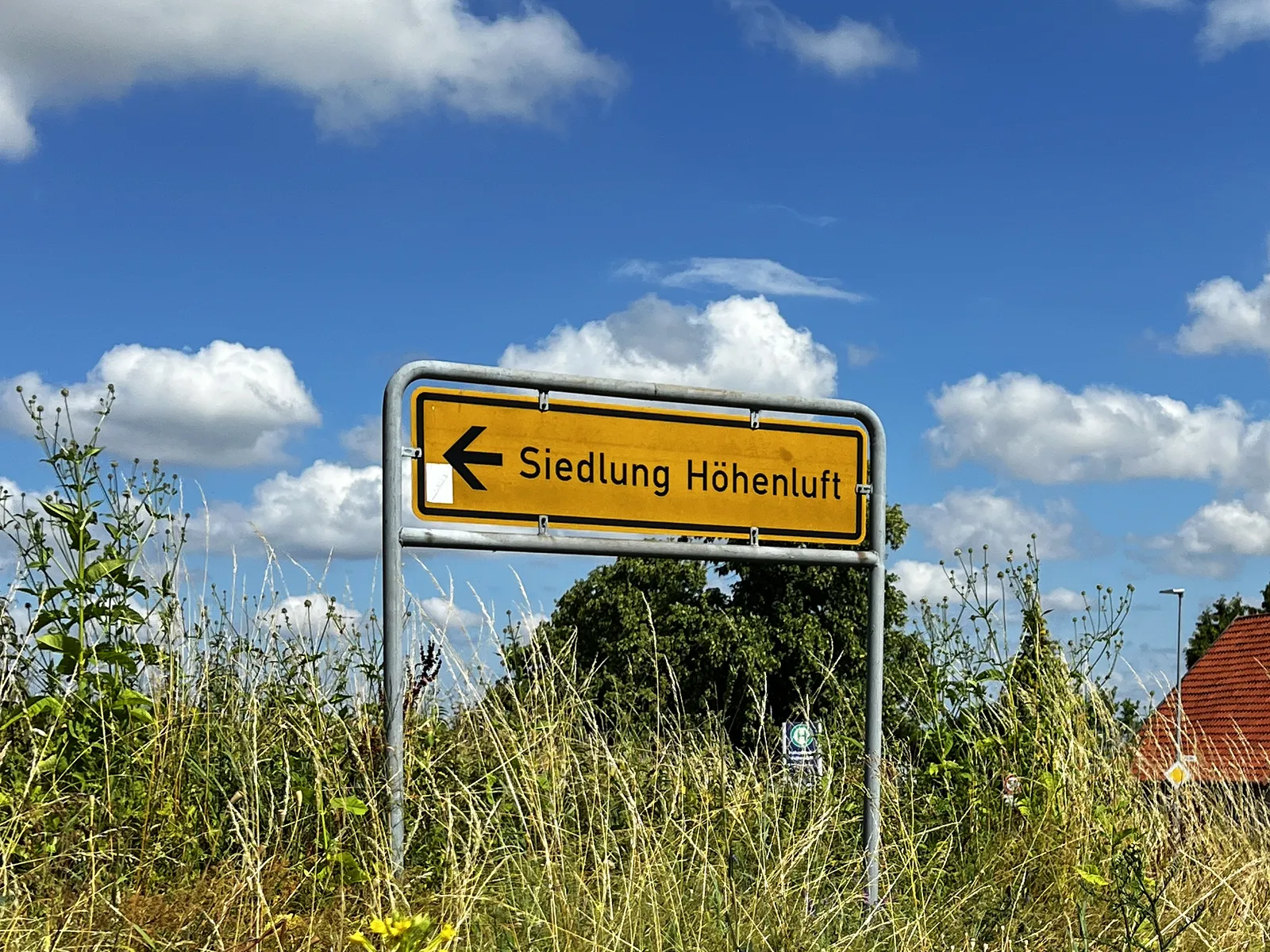 Gelber Wegweiser zur Siedlung Höhenluft an der Ortsdurchfahrt von Hohenbostel