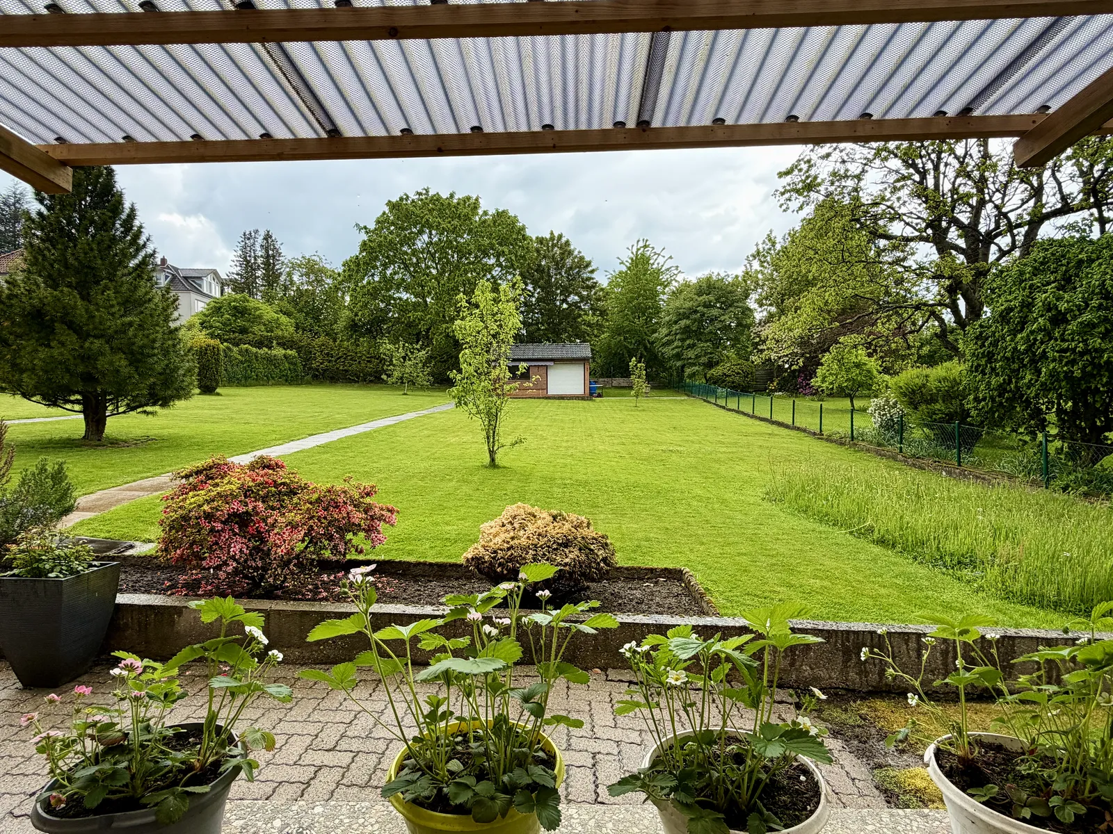 Terrasse mit Pergola und Blick in den Garten eines Hauses in der Siedlung Höhenluft, Hohenbostel