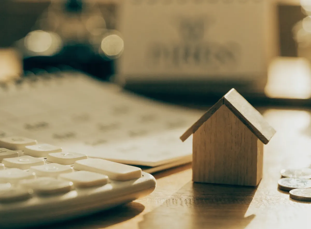 Rechner, Kalender und Modellhaus — Steuern beim Immobilienverkauf